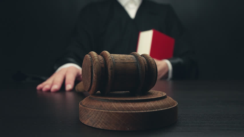judge in a courtroom is hitting with gavel