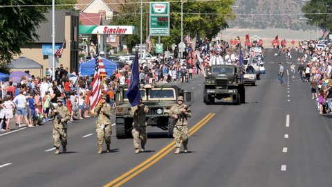 MORONI, UTAH-JULY 4, 2017:Crowds line the Main Street of a small town USA as National Guard members march US and Utah state flag starting annual 4th of July Parade kicking off the holiday celebrations
