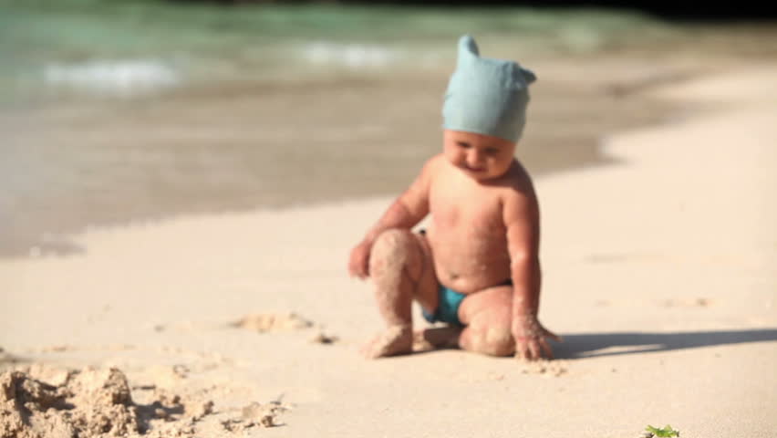 Adorable toddler crawling on the sand