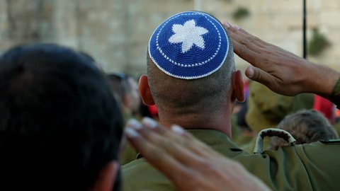 Jerusalem, Israel - May 25, 2017: Israeli soldier military man saluting to the Western wall in Jerusalem. Western wall or Wailing wall or Kotel is the most sacred place for all jewish people.