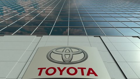 Signage board with Toyota logo. Modern office building facade time lapse. Editorial 3D rendering