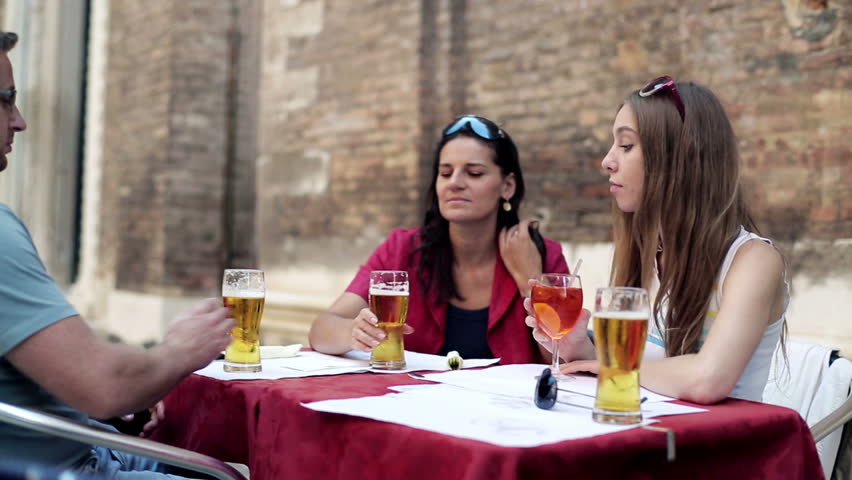 Group of friends drinking beer in the restaurant, outdoors

