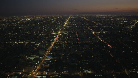 Aerial cityscape view of vehicle traffic showing grid system in illuminated city suburbs at dusk Los Angeles California USA RED EPIC