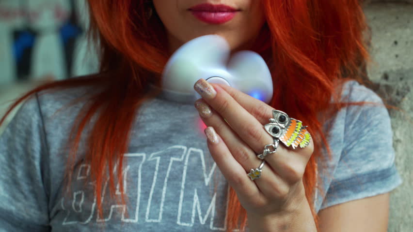Beautiful red hair girl play with spinner relax and smiling close-up