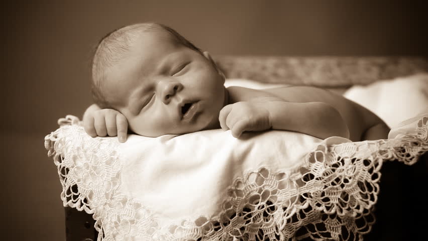 Close-up portrait of a beautiful sleeping baby on vintage suitcase