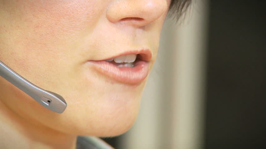 Girl talking on headset in a call centre. Close up.