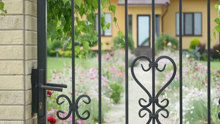 young woman coming home, opening, closing gate yard summer.