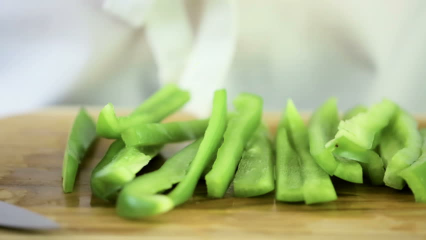 Slicing green bell pepper on a wood cutting board. | Shutterstock HD Video #29040688