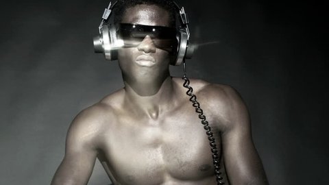 sequence of a young cool african guy dancing with headphones and glasses on a black background. High contrast.

