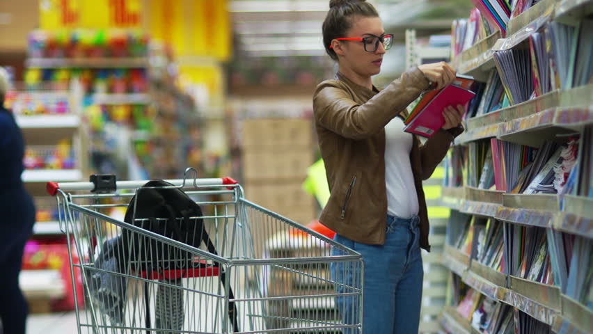 Young beautiful woman buying stationery for school, beautiful mother choose tools in a supermarket for her children, student shopping in a supermarket Royalty-Free Stock Footage #29051284