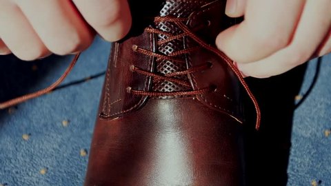Man tying patent leather shoes. / Man tying patent leather shoes formal and festive dressing. Slow motion. Close up