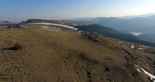 4K aerial footage of Transbucegi the highest altitude mountain road in Romania. Beautiful landscape in early spring, a sunny day with blue sky and a little bit of snow.