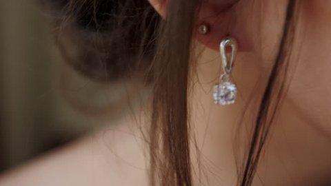 The young woman puts on beautiful earrings