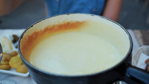 A traditional Swiss food: the fondue cheese. Slowmotion