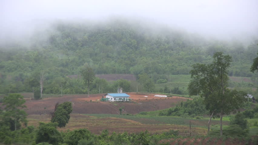 A heavy fog hangs over a cute little farm house in the mountainous region of Western Thailand.
