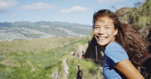 Cheerful female hiker with windswept hair standing on observation point at Diamond Head State Monument. Happy young woman is enjoying summer vacation in Oahu, Hawaii, USA. SLOW MOTION RED EPIC.