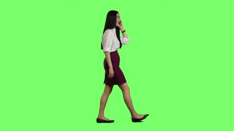 Manager girl goes to her phone rings and she starts talking. Green screen. Side view. Slow motion