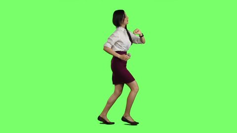Girl with a phone is running to an important meeting. Green screen. Slow motion