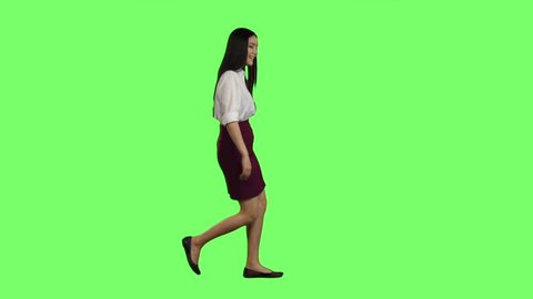 Girl of asian appearance goes to work and waves her hand. Green screen. Side view. Slow motion