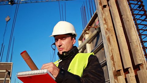 Construction supervisor;builder oversees the construction works and talk to the workers on the intercom,video clip