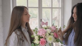 Florists at work: pretty young girls making fashion modern bouquet of different flowers