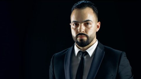 Professional Magician in a Dark Suit Creates Spectacular Illusion Where White Napkin Turns into White Parrot. Shot with Black Background. Shot on RED EPIC-W 8K Helium Cinema Camera.