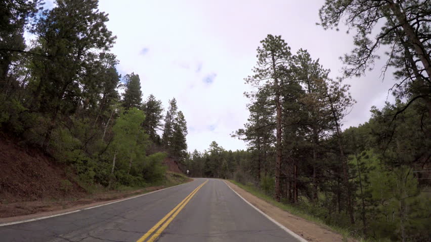 POV point of view -Driving on small road near the mountain creek in rural area of Western Colorado.