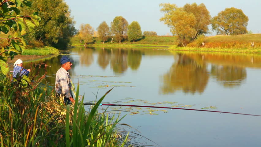 fishing senior couple on autumn lake - timelapse