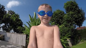 Joyful Boy With a Camera in His Hands Jumping Into the Pool and Taking Himself Video to Camera