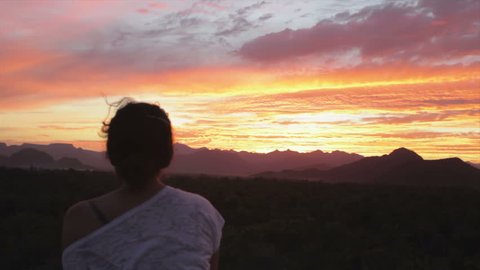 Woman watching sunset over the mountains in Baja California, Mexico