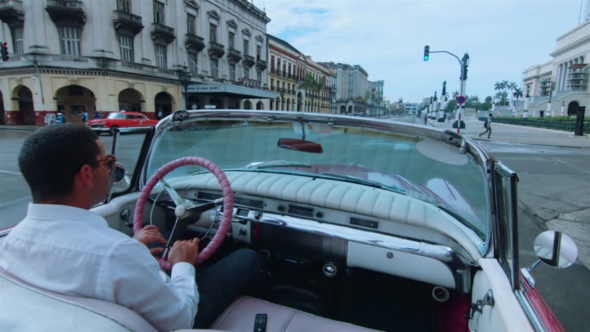 Cuban chauffeur driving through Habana, Cuba. Royalty-Free Stock Footage #29114656