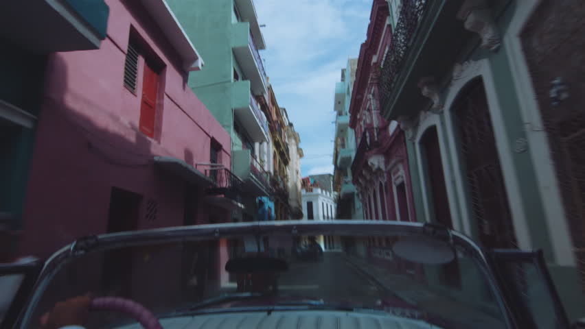 Cuban chauffeur driving through Havana, Cuba.