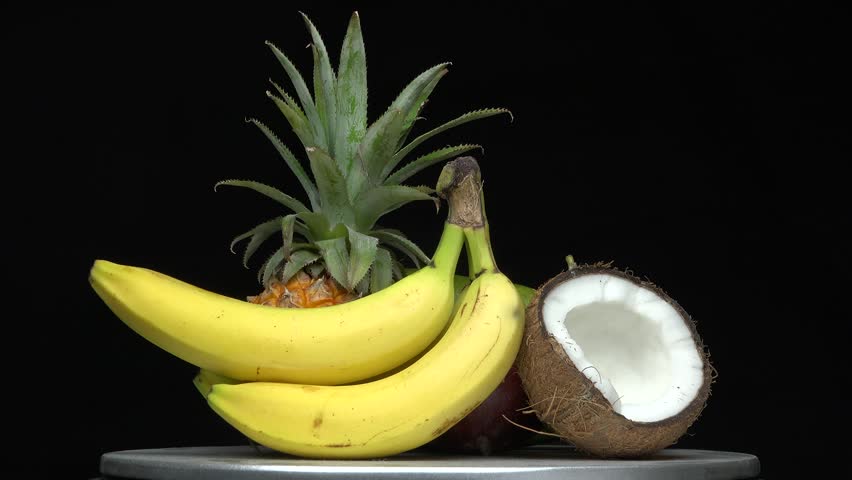 Detail of exotic fruit on rotary table, black background studio