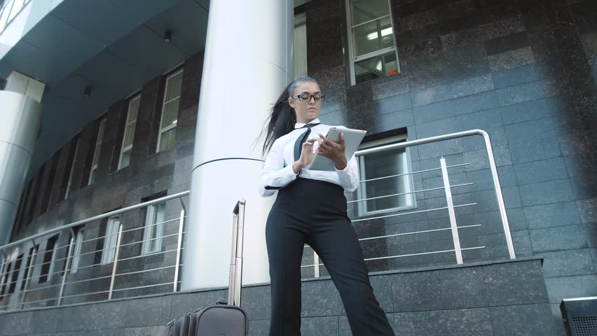 Portrait of a young sexy in suit business woman smiling, in an office environment, brunette arabian tanned businesswoman with tablet pc