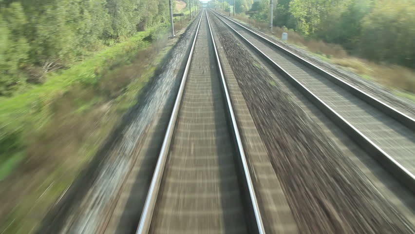train passing through countryside, moving railroad tracks
