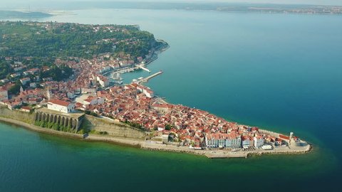 4K. Flight over old city Piran in the morning, aerial top panoramic view with old houses, Tartini Square, St. George's Parish Church, fortress and marina.