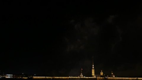 Peter and Paul fortress, famous landmark at night time. Tall spire of cathedral rise high over fort walls, illuminated at night. Black sky, copy space version of footage