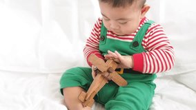Happy Baby Playing With Toy Wood Airplane. 