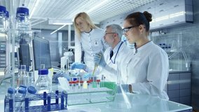 Team of Research Scientists Working With Personal Computer, Analysing Test Trial New Generation Drug Data. They Work in a Modern Laboratory/ Medical Center. Shot on RED EPIC-W 8K Helium Cinema Camera. - Powered by Shutterstock - Get 15% off with code: PIKWIZARD15