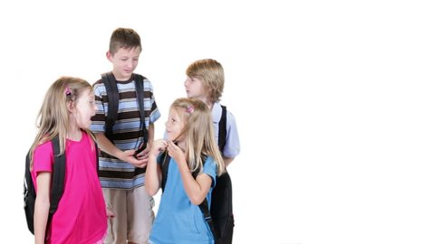 Four school age children playfully interacting stop chatting and smile for the camera. On Green screen