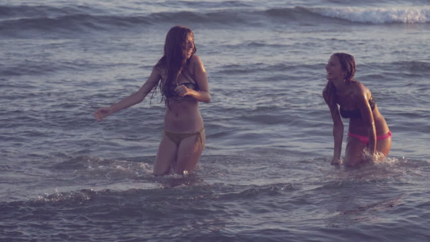 Happy girls playing in the sea in summer slow motion retro style