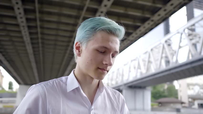 portrait of a male punk with blue hair and a white shirt. modern informal youth