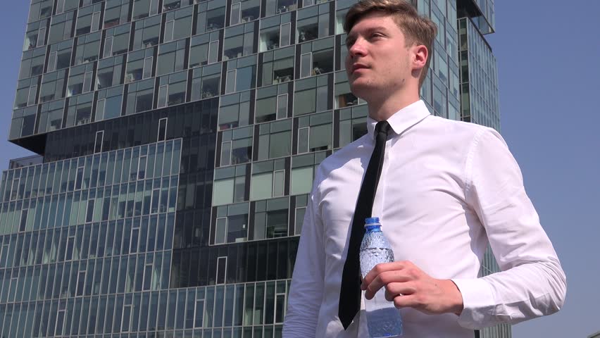 Relaxed sales man businessman outdoors lunch break drinking water checking watch