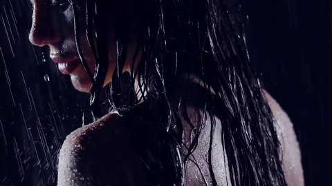 close-up portrait of a girl in the rain in the dark. in the face of flowing water. she was wet and naked
