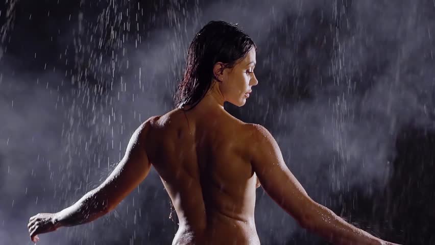 Sexy middle-aged woman standing in the rain naked. his arms around and medi...