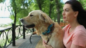 Beautiful woman sitting on the bench with her dog