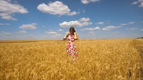 young lady in a dress standing in a wheat field