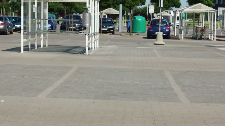 A young man is riding a trolley in a parking lot near a supermarket. The basket is full of products. Fun and good mood. Merry shopping. Dad buys food