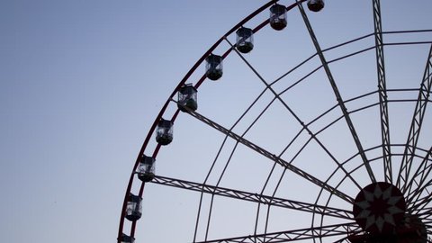 The Ferris wheel is spinning. Part of the wheel in the frame. 库存视频