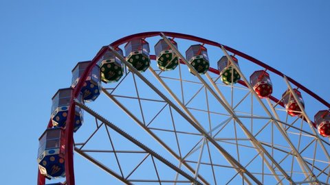 The Ferris wheel is spinning. Part of the wheel in the frame.